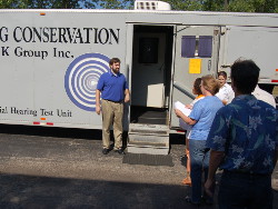 Workers approaching mobile hearing unit