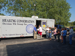 Workers entering hearing testing mobile unit