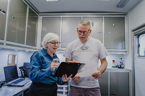 Hearing technician explains results to worker